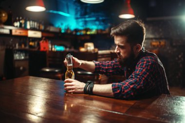 genç adam açılış şişe bira bar sayacı, alkolizm, sarhoşluk kavramı