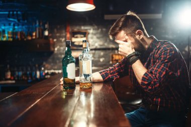 şişe viski bar sayacı, alkolizm, sarhoşluk kavramı ile genç adam