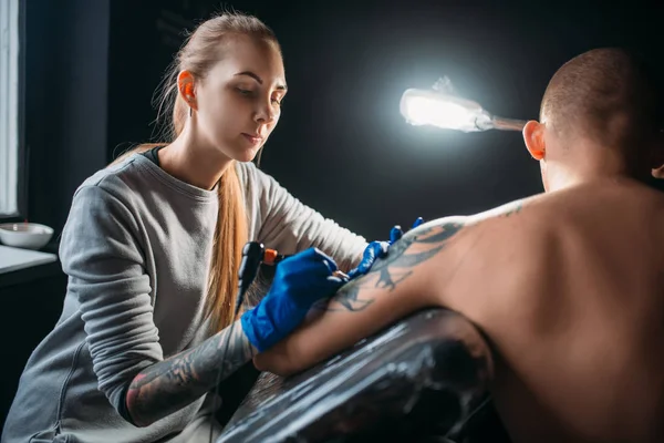 Женщина Татуировщица Делает Татуировку Автоматом Мужском Плече Профессиональная Татуировка Салоне — стоковое фото