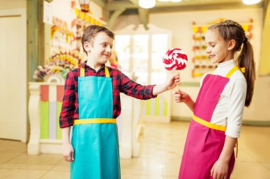 küçük çocuk mutlu kıza el yapımı lolipop veriyor