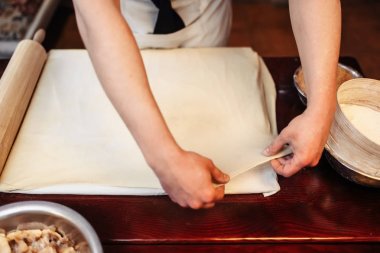 erkek Şef hamur elma meyveli turta için ahşap mutfak masasında yapma