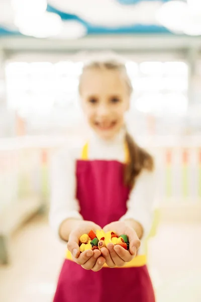 手作りキャラメルお菓子を手に保持している幸せな少女 — ストック写真