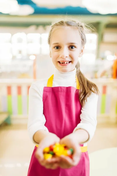 手作りキャラメルお菓子を手に保持している幸せな少女 — ストック写真