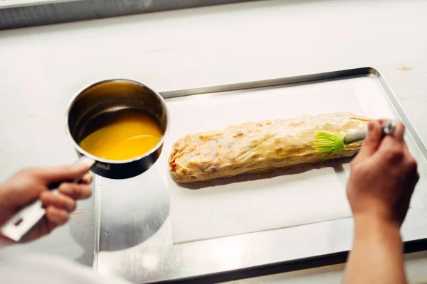 Manliga Chef Som Täcker Apfelstrudel Med Ägg Och Smör — Stockfoto