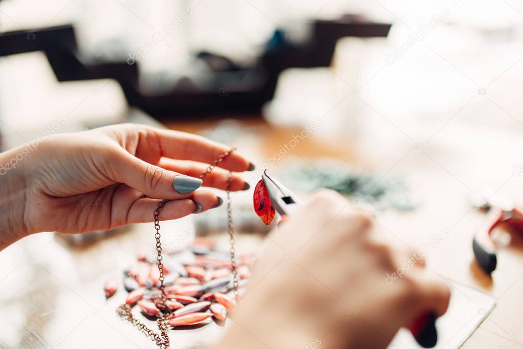 woman holding pliers, master at workplace, handmade jewelry, needlework, fashion bijouterie making