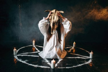 eller, mumlar, kara büyü ritüel, yöneltici pentagram daireyle hayvan kafatasında tutan kadın