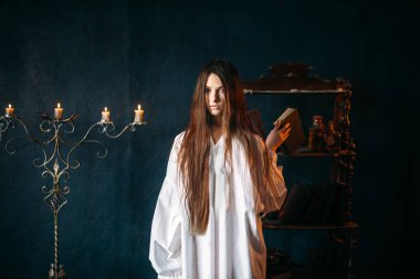 Beyaz gömlekli spellbook, tutan genç cadı mumlar arka plan, blackmagic ritüel, büyü ve şeytan, büyücülük