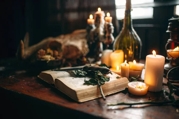 witchcraft, black magic, candles with ritual book on table, occult and esoteric symbols