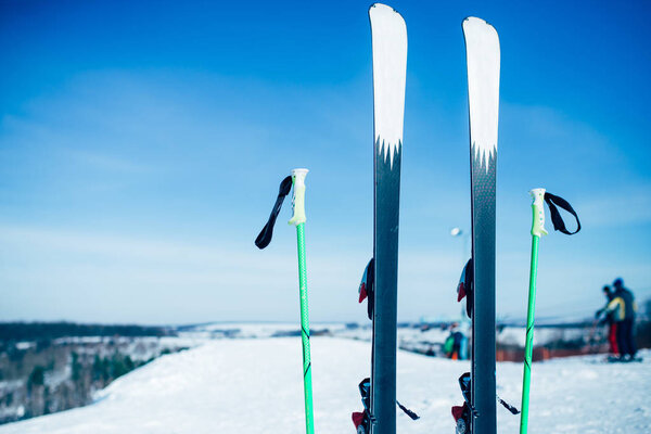 skis and poles sticking out of snow closeup. Winter active sport concept