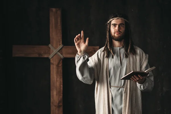 Santo Jesucristo Orando Con Biblia Las Manos Cruz Sobre Fondo — Foto de Stock