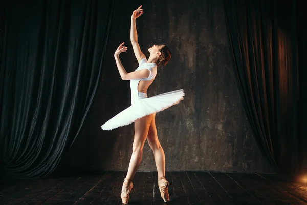 graceful and beautiful ballerina in white costume dancing in ballet class