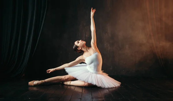 graceful and beautiful ballerina in white costume dancing in ballet class