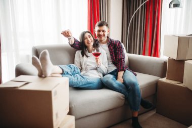aşk çift oturma yakınındaki karton kutular, kırmızı şarap içme ve yeni evine taşınıyor kutluyor
