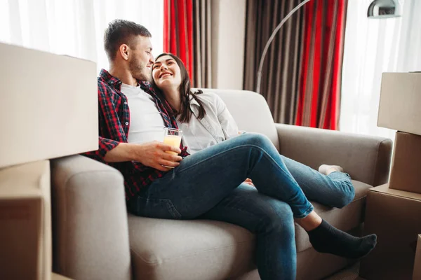 Yeni eve taşınma karton kutular arasında oturan mutlu çift