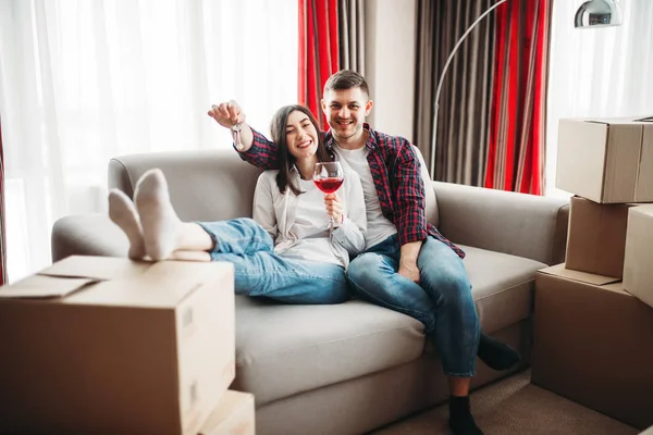 aşk çift oturma yakınındaki karton kutular, kırmızı şarap içme ve yeni evine taşınıyor kutluyor