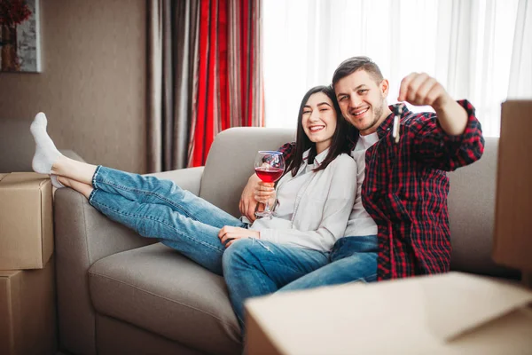 Счастливая Пара Пьет Красное Вино Показывает Ключи Против Картонных Коробок — стоковое фото