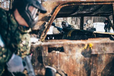 Paintball çatışma, kış orman yandı araç etrafında oyuncular mücadele
