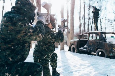 Paintball çatışma, kış orman yandı araç etrafında oyuncular mücadele