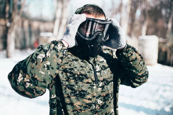 Male Paintball Player Puts Protection Mask Winter Forest Battle Extreme — Stock Photo, Image