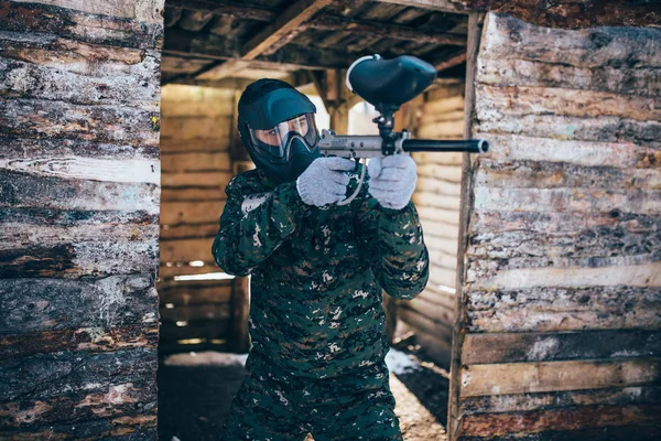 冬の森の戦いの手でマーカー銃を持つ男性の Paintball プレーヤー — ストック写真