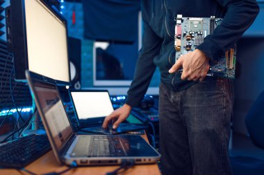 Computer engineer holds PC motherboard, network equipment maintenance. IT-manager at his workplace, professional business security clipart