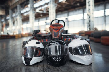 Araba ve miğferleri yere bırakın, kapalı alanda araba sporu yapın. Hız yarışı go-kart pisti. Hızlı araç yarışması, sıcak takip