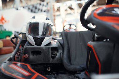 Go kart arabasının kaskı, kapalı mekanda karting otomobil sporu. Hız yarışı go-kart pisti. Hızlı araç yarışması, sıcak takip