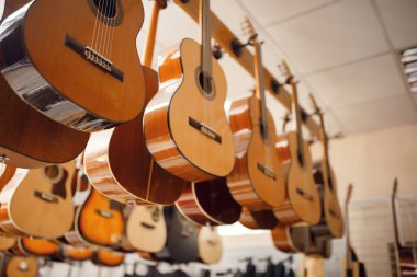 Rows of acoustic guitars on showcase in music store, nobody. Assortment in musical instrument shop, professional equipment for musicians and performers clipart