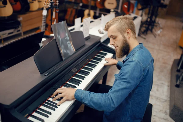 Male Musician Trying Play Piano Music Store Assortment Musical Instruments — Φωτογραφία Αρχείου