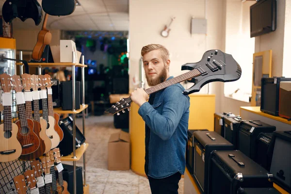 Mladík Pózuje Elektrickou Kytarou Rameni Hudebním Obchodě Sortiment Obchodě Hudebními — Stock fotografie