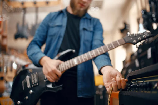 男性ギタリストはミュージックストアでエレキギターを演奏する 楽器店での品揃え 楽器を購入する音楽家 — ストック写真