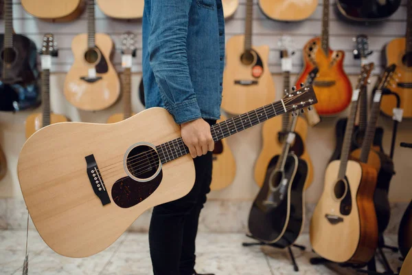 Müzik Dükkanında Akustik Gitar Tutan Genç Bir Adam Müzik Aletleri — Stok fotoğraf