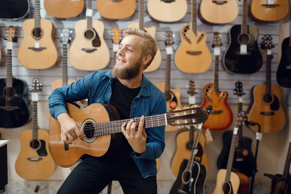 Jongeman Speelt Akoestische Gitaar Muziekwinkel Assortiment Muziekinstrumentenwinkel Mannelijke Muzikant Die — Stockfoto