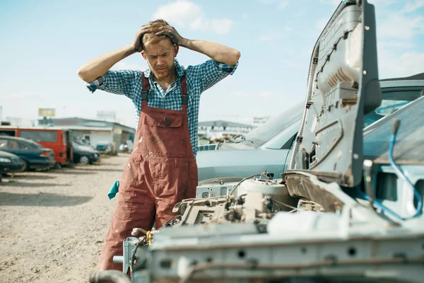 愤怒的男性修理工在汽车垃圾场工作 汽车废料 车辆垃圾 汽车垃圾 损坏和压碎的运输 — 图库照片
