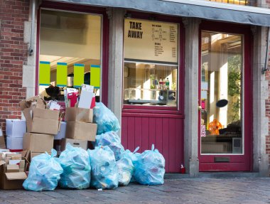 Avrupa 'da kaldırımda mavi çöp torbaları ve kutular. Avrupa 'da sokakta tam çöp kutusu, hiç kimse, çöp tenekesi, açık hava paketleri.