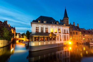 Belçika, Brugge, nehirde binaları, gece görüşü olan eski Avrupa kasabası. Turizm ve seyahatler, Avrupa 'nın ünlü simgesi
