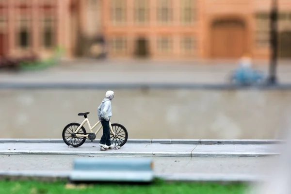 男人与自行车在城市街道上 微型场景户外 具有高度吸引物体的迷你人物 现实的全景图 玩具模型 — 图库照片
