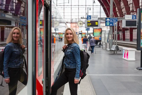 バックパックを持つ女性観光客は 鉄道駅のプラットフォーム上の列車に入り ヨーロッパでの旅行 ヨーロッパの鉄道 快適な観光や旅行による輸送 — ストック写真