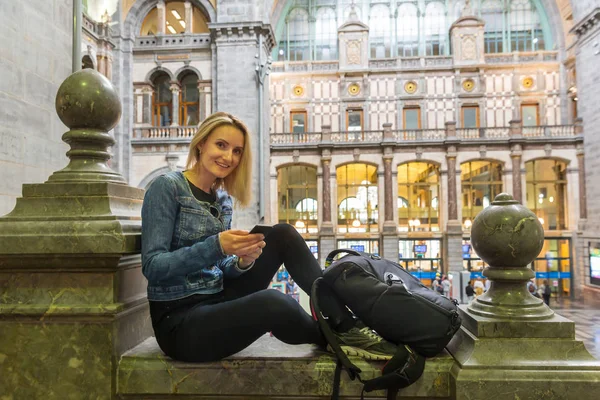Улыбающаяся Туристка Телефоном Ждет Поезд Старом Железнодорожном Вокзале Путешествует Европе — стоковое фото