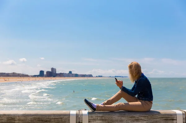 Touriste Féminine Assise Sur Jetée Sur Plage Ville Côte Mer — Photo