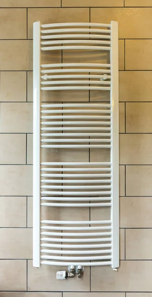 Heated towel rail in hotel bathroom closeup, Europe tourism. European motel furniture for personal hygiene, apartment for comfortable leisure, nobody