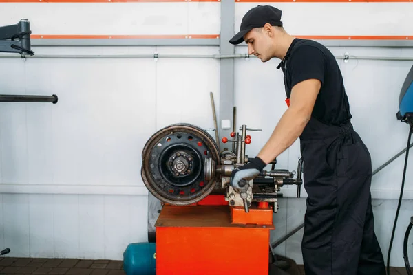 修理工的工作与折皱盘 轮胎修理服务 修车厂的人工修车轮胎 车间的专业汽车检验 — 图库照片