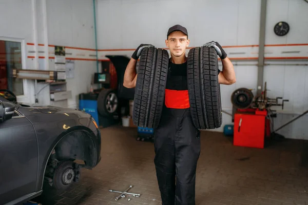 Riparatore Auto Uniforme Tiene Due Nuovi Pneumatici Servizio Riparazione Riparazioni — Foto Stock