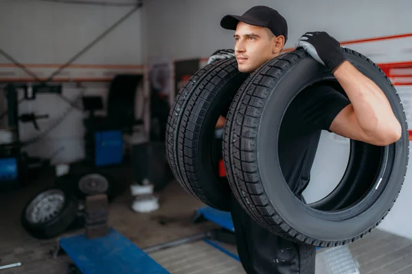 Auto Mechanik Mundurze Posiada Dwie Nowe Opony Serwis Naprawy Remonty — Zdjęcie stockowe