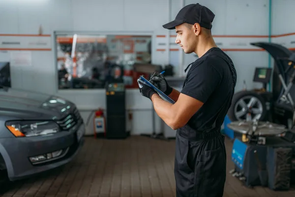 Bilmekaniker Uniform Håller Inspektionsrapport Däckservice Arbetstagare Reparerar Bildäck Garage Professionell — Stockfoto