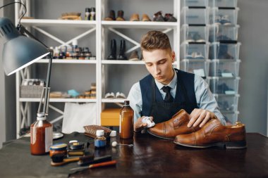 Ayakkabı tamircisi ayakkabıyı cilalar, ayakkabı tamir hizmeti verir. Zanaatkarlık yeteneği, ayakkabı yapma atölyesi, usta çizmelerle çalışır, ayakkabı tamircisi.