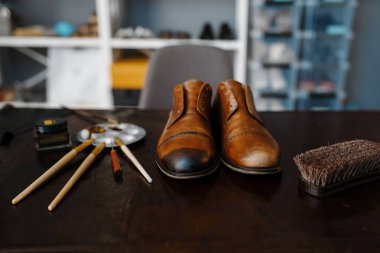Ayakkabıcı işi, ayakkabı tamir hizmeti konsepti. Ayakkabı yapma atölyesi, tamir edilmiş botlar ve masada ayakkabı yapma aletleri, ayakkabı tamirciliği.