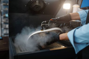 Ayakkabı tamircisi ayakkabıları özel makinede, ayakkabı tamir servisinde inceler. Zanaatkarlık yeteneği, ayakkabı yapma atölyesi, usta çizmelerle çalışır.