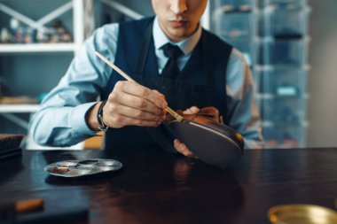 Ayakkabı tamircisi siyah ayakkabı boyası, ayakkabı tamircisi. Zanaatkarlık yeteneği, ayakkabı yapma atölyesi, usta çizmelerle çalışır.