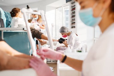 İki kız arkadaş, güzellik salonunda pedikür. Profesyonel güzellik uzmanları ve kadın müşteriler, ayak tırnağı bakımı